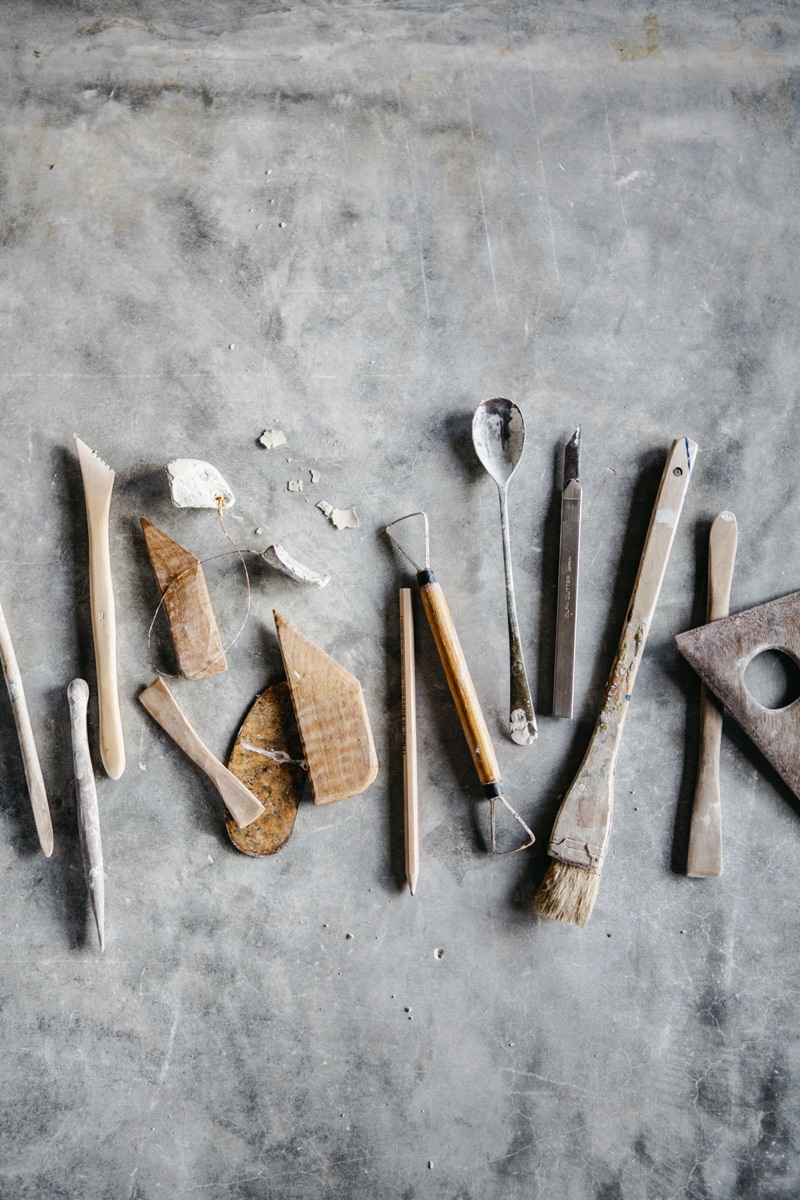 Nanna Bayer working with clay tools at her workbench, photographed by Luisa Brimble